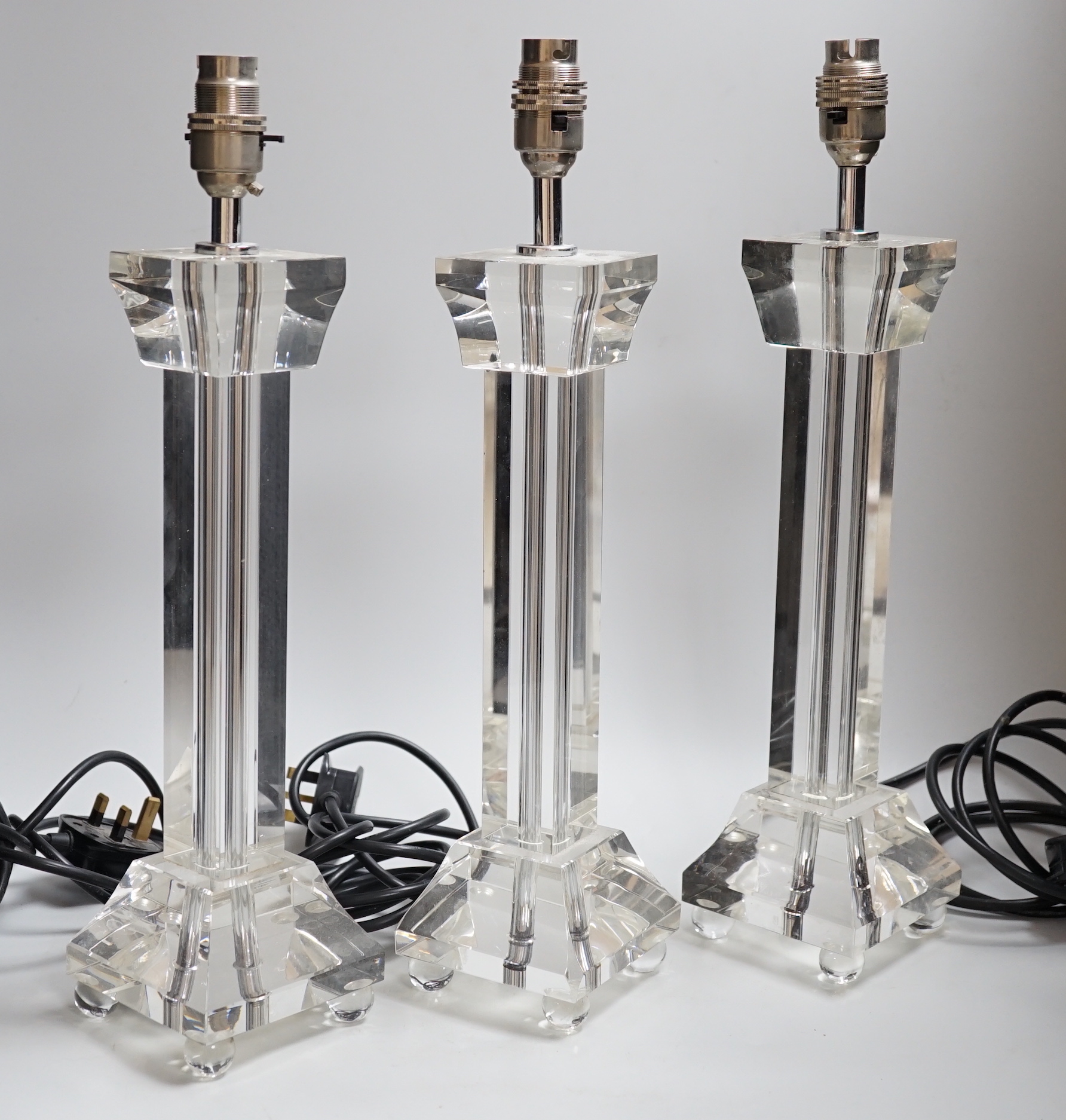 Three clear glass pillar table lamp bases, 4cm high